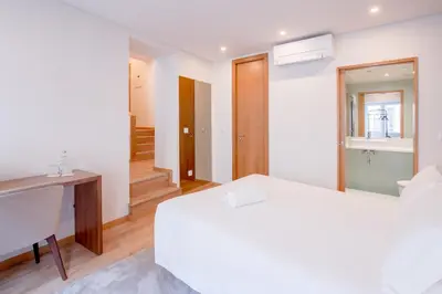 a bedroom with a bed and a desk and a mirror at Alliança Suites 1909 - Porto in Porto