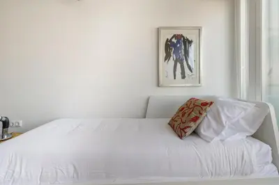 a white bed with a pillow on top of it at Design Poveiros Duplex in Porto