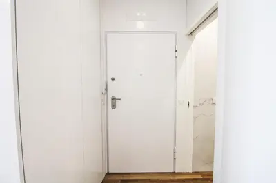 a white door in a white room with a mirror at Heroísmo Cosy Loft in Porto
