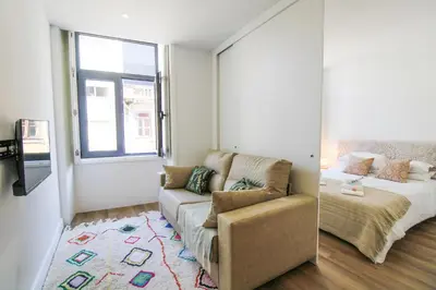 a living room with a couch and a bed at Heroísmo Cosy Loft in Porto