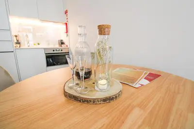 a table with a bottle and two glasses on it at Heroísmo Cosy Loft in Porto