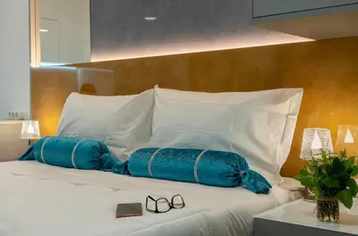 a bed with two blue pillows and a pair of shoes at 24 Porto Novíssímo Estudio em Cedofeita AC Olive in Porto