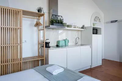 a kitchen with a bed and a sink in a room at GuestReady - Beer Garden in Porto