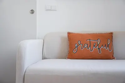 a pillow with the word faith sits on a couch at GuestReady - Beer Garden in Porto