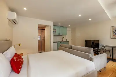 a bedroom with a white bed and a living room at Dasi House in Porto