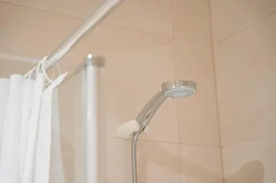a shower head in a bathroom with a shower curtain at GuestReady - Casa da Música Cosmopolitan Comfort in Porto