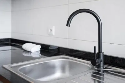 a kitchen sink with a faucet on a counter at GuestReady - Casa da Música Cosmopolitan Comfort in Porto