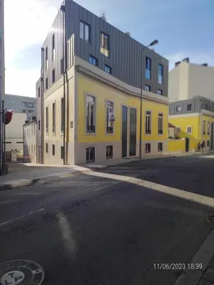 a yellow and white building on the side of a street at 25 Porto Novíssímo Estudio em Cedofeita AC Olive in Porto
