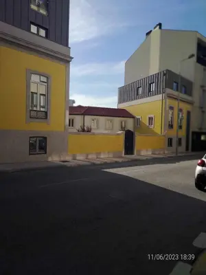 a yellow building on the side of a street at 25 Porto Novíssímo Estudio em Cedofeita AC Olive in Porto