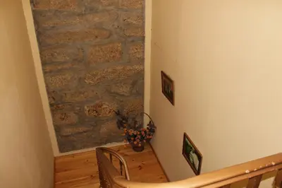 a hallway with a stone wall and a staircase at Guest House Estrela in Porto