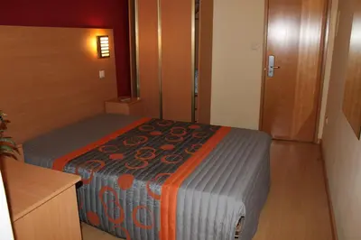 a small bedroom with a bed in a room at Guest House Estrela in Porto