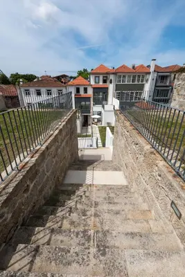 a retaining wall in front of some buildings at Porto Grandeur Collection - D. João IV Pool & Garden Apartment in Porto