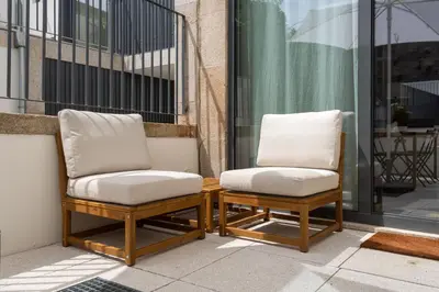 two chairs with white cushions sitting on a balcony at Porto Grandeur Collection - D. João IV Pool & Garden Apartment in Porto