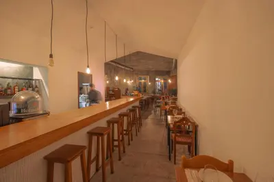 a restaurant with a long bar with wooden chairs at Babel in Porto