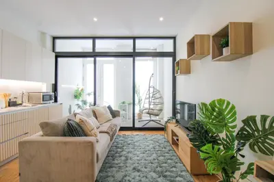 a living room with a couch and a large window at La Vida in Porto Unique in Porto