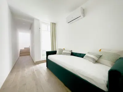 a white room with a large bed and a couch at Vibrant Host-Campo 24 Agosto in Porto