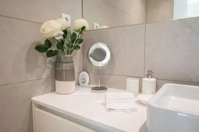 a bathroom with a vase of flowers on a counter at Loft in Porto in Porto