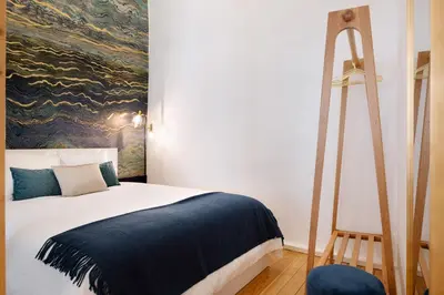 a bedroom with a bed with a painting on the wall at Sao Domingos Stylish Apartment in Porto