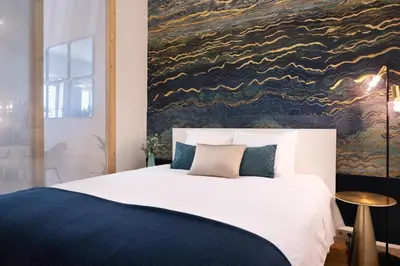 a bedroom with a large bed with a painting on the wall at Sao Domingos Stylish Apartment in Porto