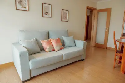 a couch with four pillows on it in a living room at Bright Apartment by Hosty in Porto