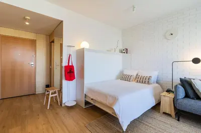 a bedroom with a large white bed and a couch at S1405 - practical and modern - AC, balcony and parking in Porto