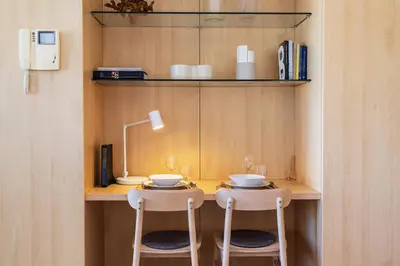 a small table with two stools in a room at S1405 - practical and modern - AC, balcony and parking in Porto