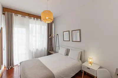 a white bedroom with a white bed and a window at Lolla's City House 2 in Porto