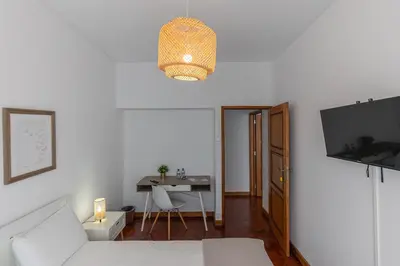a living room with a white couch and a table at Lolla's City House 2 in Porto