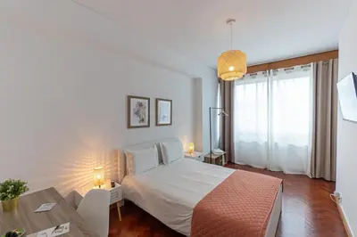 a bedroom with a white bed and a table at Lolla's City House 2 in Porto