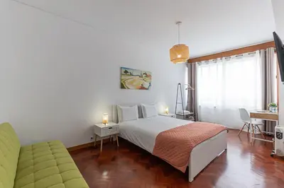 a hotel room with a bed and a couch at Lolla's City House 2 in Porto