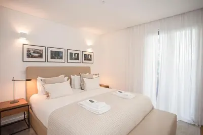 a white bedroom with a bed with two towels on it at Liiiving in Gaia - Cooper Residence Apartment II in Vila Nova de Gaia