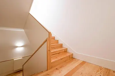 a staircase in a room with white walls and wooden floors at Cozy and Homely Getaway by LovelyStay in Porto