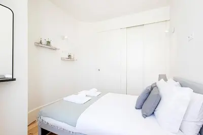 a white bedroom with a bed with white pillows at Cozy and Homely Getaway by LovelyStay in Porto