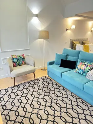 a living room with a blue couch and a chair at luxury stay Romantic Douro River & Sunset views in Porto