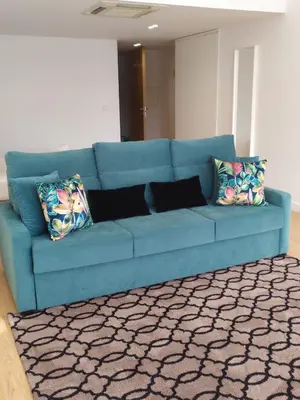 a blue couch in a living room with yellow pillows at luxury stay Romantic Douro River & Sunset views in Porto