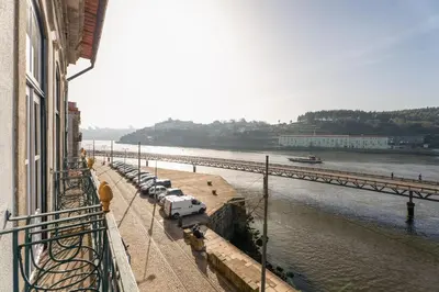a bedroom with a large bed and a green couch at luxury stay Romantic Douro River & Sunset views in Porto
