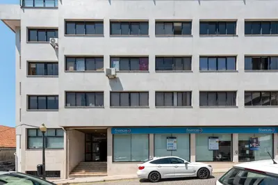 a white car parked in front of a building at DOISPONTOZERO Bragas in Porto