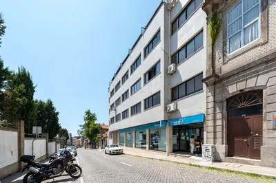 a motorcycle parked on a street next to a building at DOISPONTOZERO Bragas in Porto
