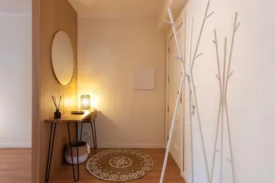 a hallway with a table and a mirror at DOISPONTOZERO Bragas in Porto