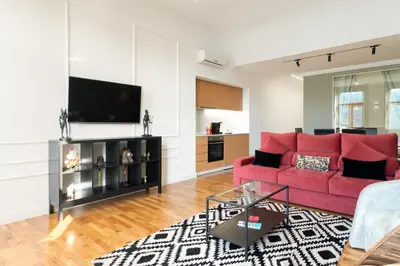 a living room with a red couch and a flat screen tv at Luxury stay Premium Douro River & Sunset views in Porto