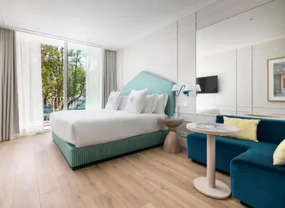 a bedroom with a large bed and a blue chair at One Shot Palácio Cedofeita in Porto