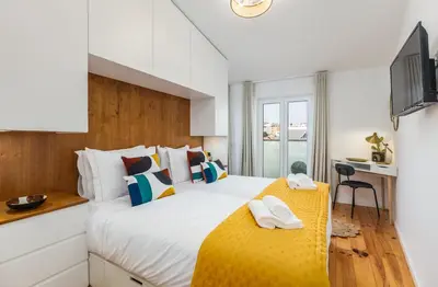 a bedroom with a large bed with a yellow blanket at OPO Vale Formoso III Balcony&BBQ in Porto