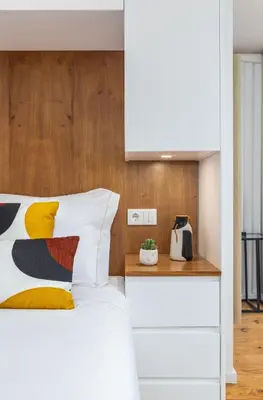 a bedroom with a white bed with a wooden headboard at OPO Vale Formoso III Balcony&BBQ in Porto