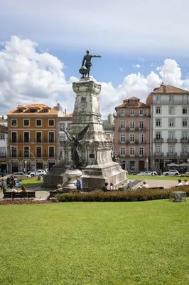 a statue in the middle of a city with buildings at OPO Vale Formoso III Balcony&BBQ in Porto