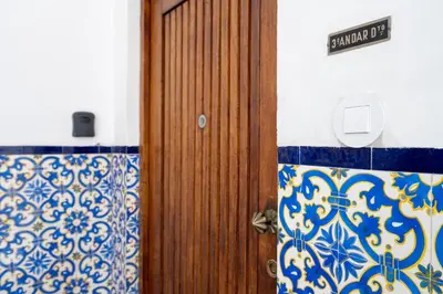 a wooden door in a room with blue and white tiles at The Flat in Porto