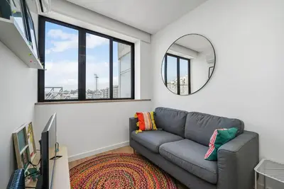 a living room with a gray couch and a mirror at Constituição Flat by Amber Star Rent in Porto