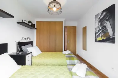 a bedroom with two beds and a desk and a lamp at Host Wise - Deluxe Modern Flat w Balcony in Porto