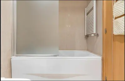 a white bath tub in a bathroom with a window at Host Wise - Deluxe Modern Flat w Balcony in Porto
