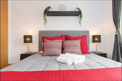 a bedroom with a large bed with red and white pillows at Host Wise - Deluxe Modern Flat w Balcony in Porto
