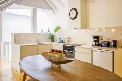 a kitchen with a table and a clock on the wall at Mouzinho 202 in Porto